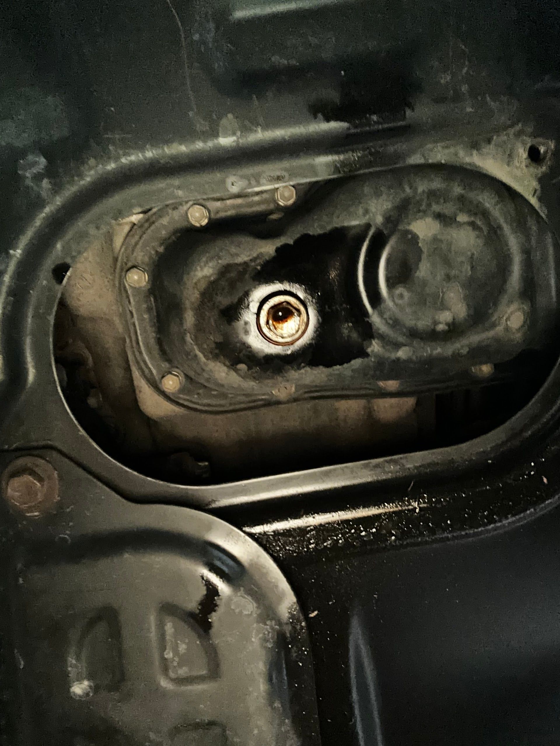 Black car part with a recessed bolt, surrounded by other components. | Lenon's Tire & Auto Repair