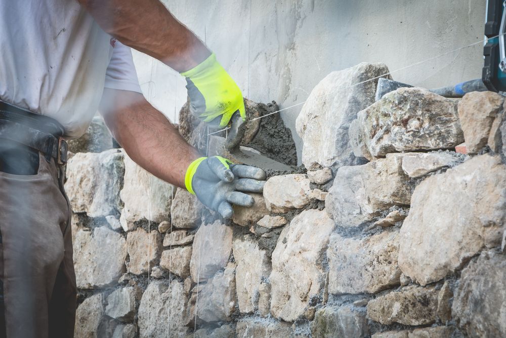 Person in Gloves Laying Stones, Applying Mortar to Construct a Wall — Verastone In Fyshwick, ACT