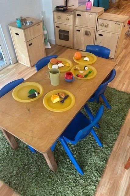 A wooden table with plates of food on it — Birralee Child Care Centre Assn Inc In Mackay, QLD