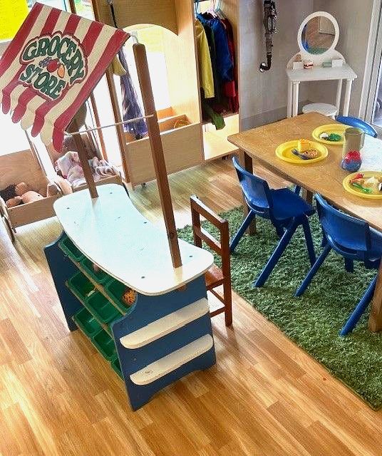 A room with a table and chairs and a sign that says grocery store — Birralee Child Care Centre Assn Inc In Mackay, QLD