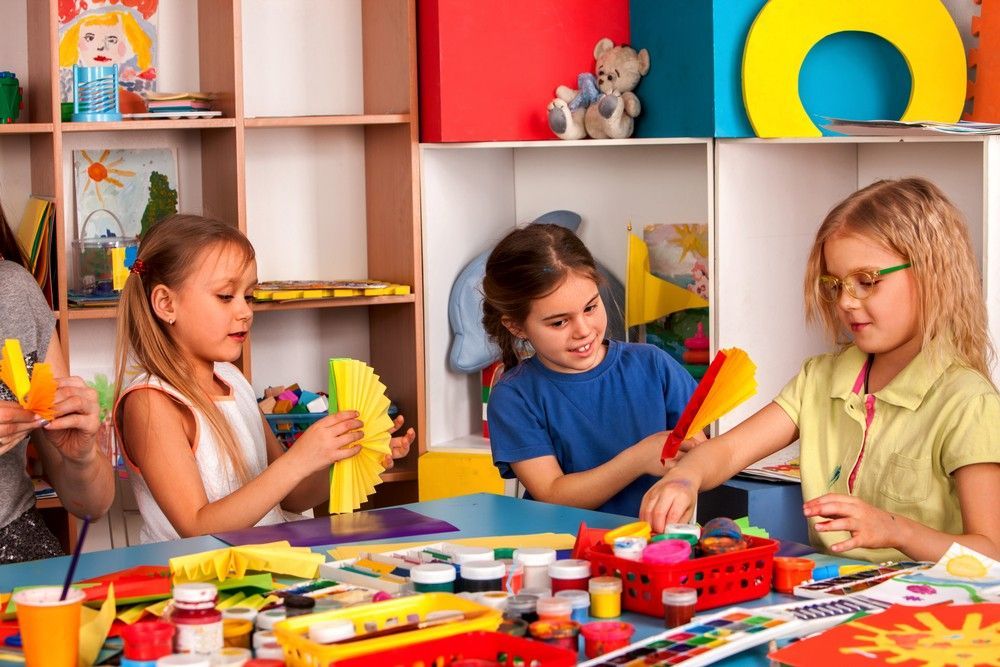 A Group of Young Girls Are Sitting at a Table Making Crafts — Birralee Child Care Centre Assn Inc In Mackay, QLD