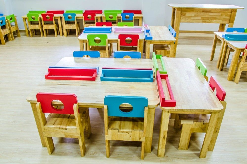 A Row of Wooden Tables and Chairs in a Classroom — Birralee Child Care Centre Assn Inc In Mackay, QLD