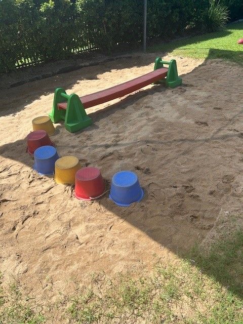 A Boy and a Girl Are Laying on the Floor Playing With Colorful Blocks — Birralee Child Care Centre Assn Inc In Mackay, QLD