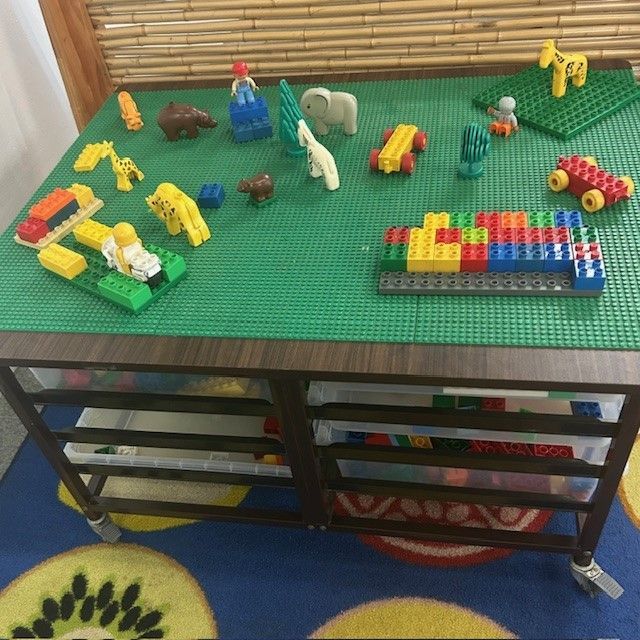 A Boy and a Girl Are Laying on the Floor Playing With Colorful Blocks — Birralee Child Care Centre Assn Inc In Mackay, QLD