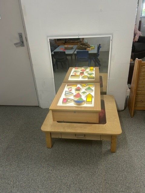 A Young Boy is Sitting at a Table Writing With a Pencil — Birralee Child Care Centre Assn Inc In Mackay, QLD