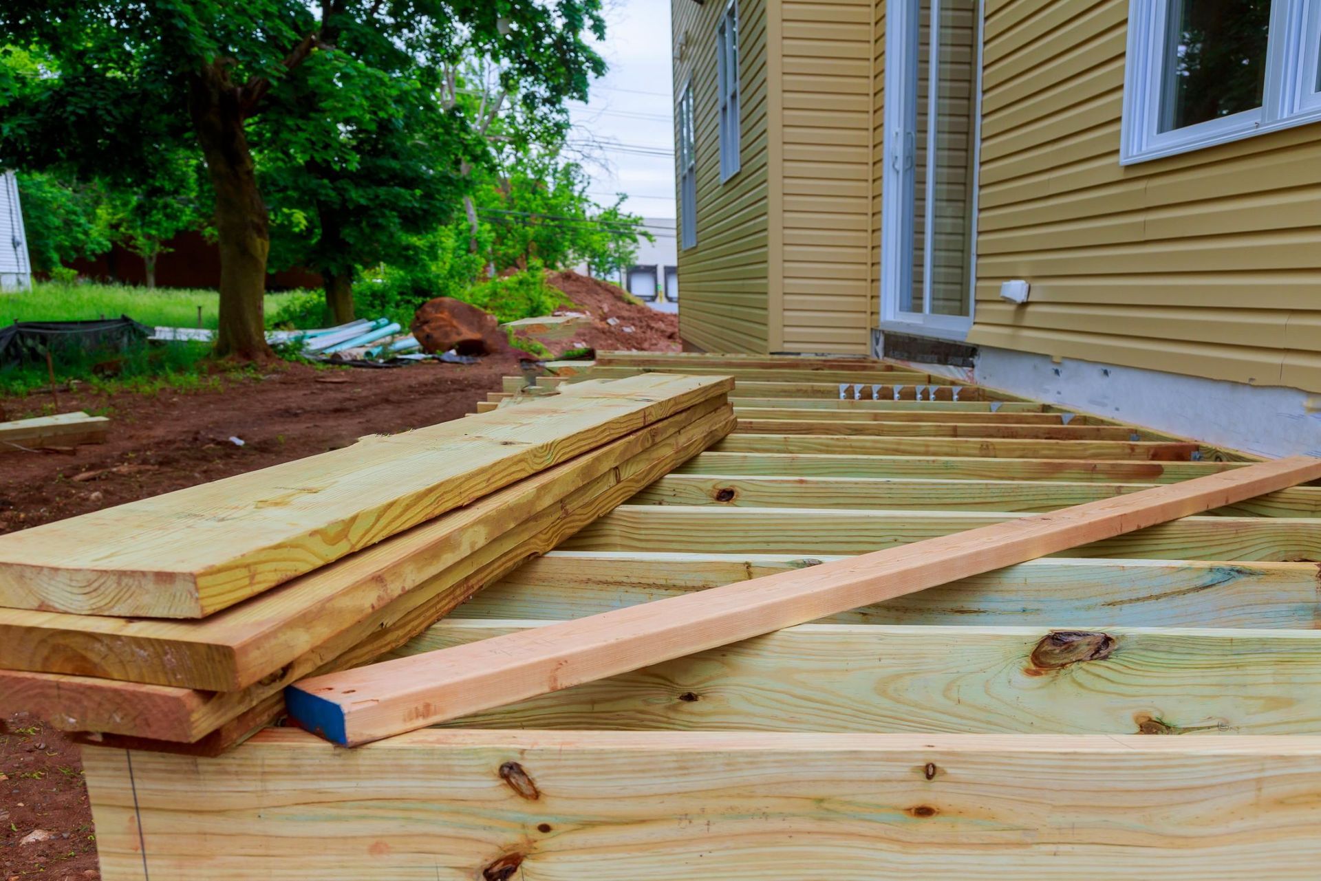 A wooden deck is being built in front of a house.