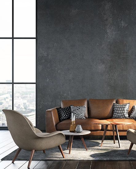 A living room with a brown leather couch, two chairs, a table ,and a large window.