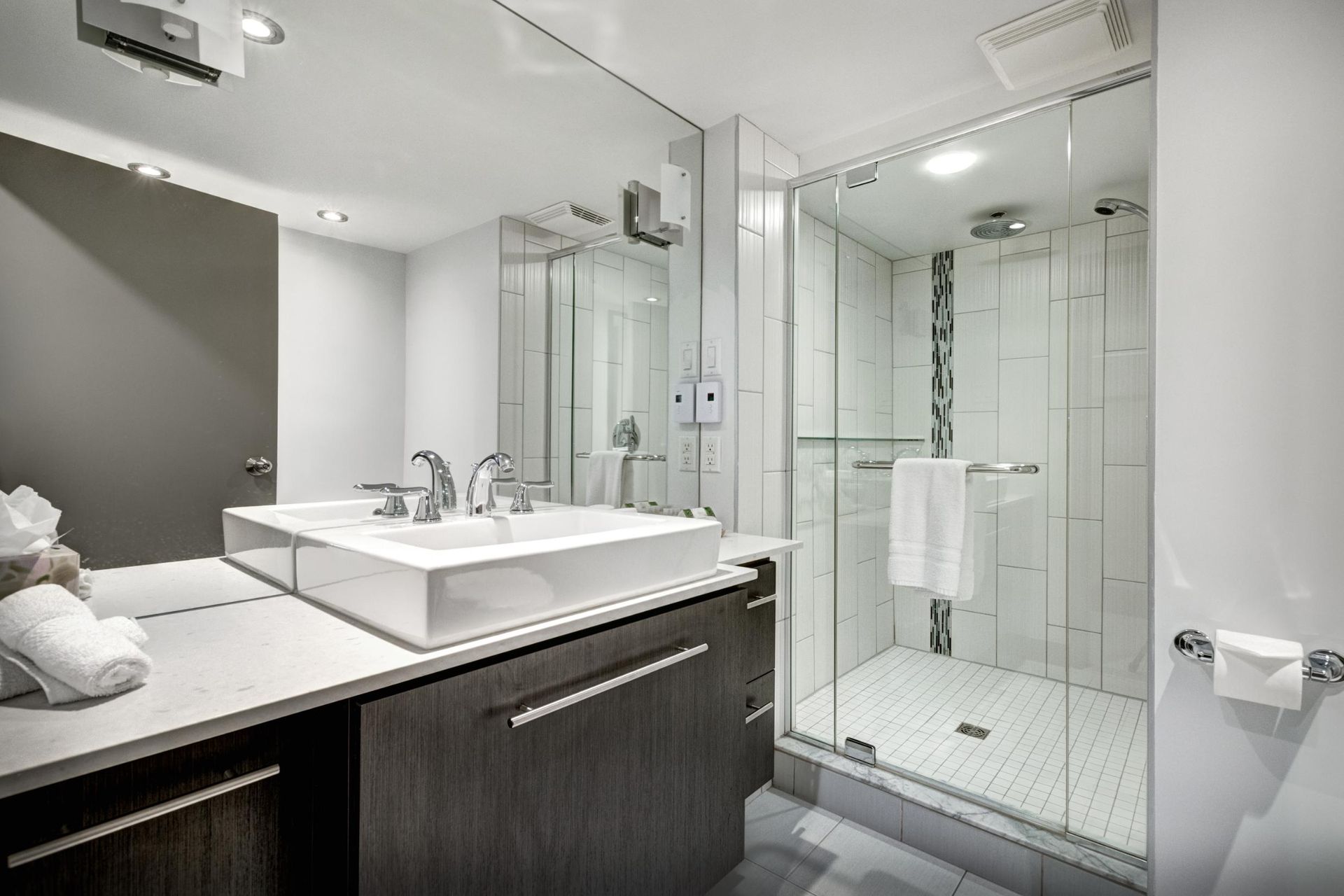 A bathroom with a sink, mirror, and walk-in shower.