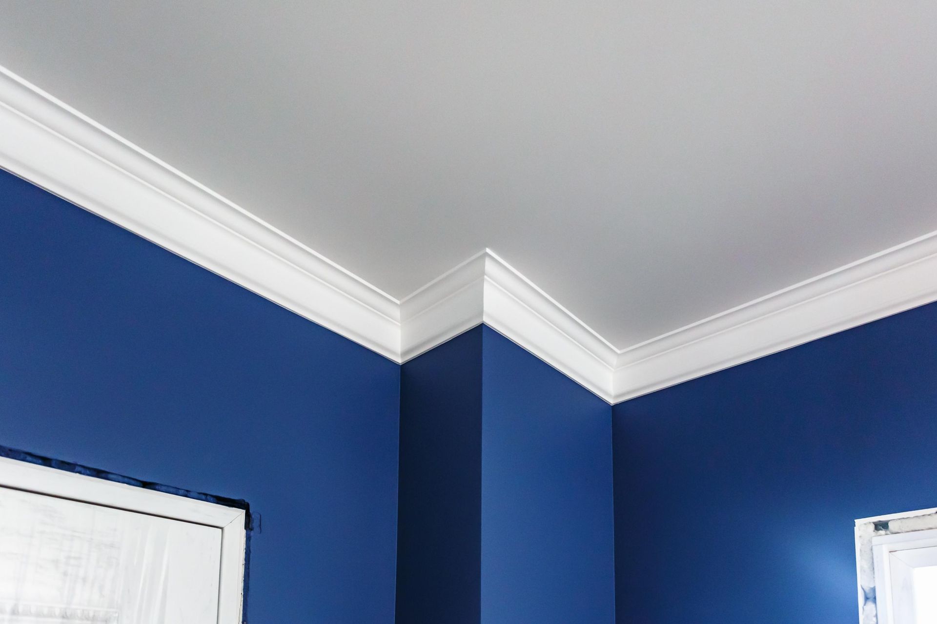 A room with blue walls and white trim on the ceiling.