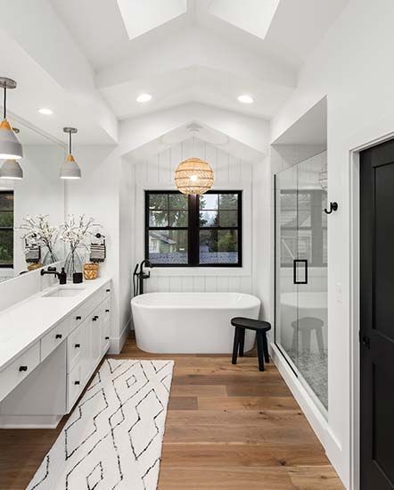 A bathroom with a tub , sink , and mirror.