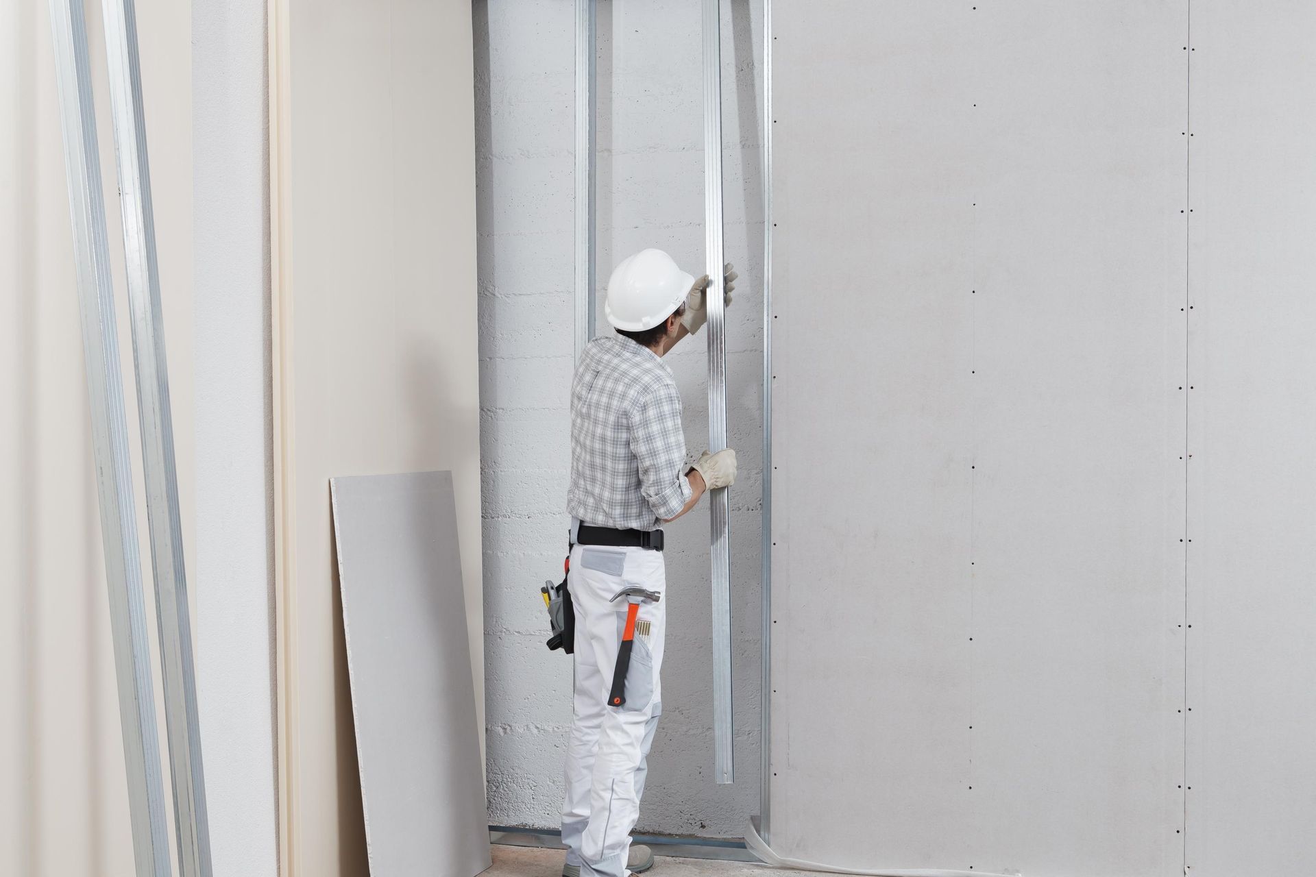 A man is working on a wall in a room.