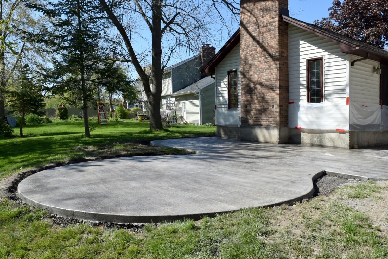 A concrete patio is being built in front of a house.