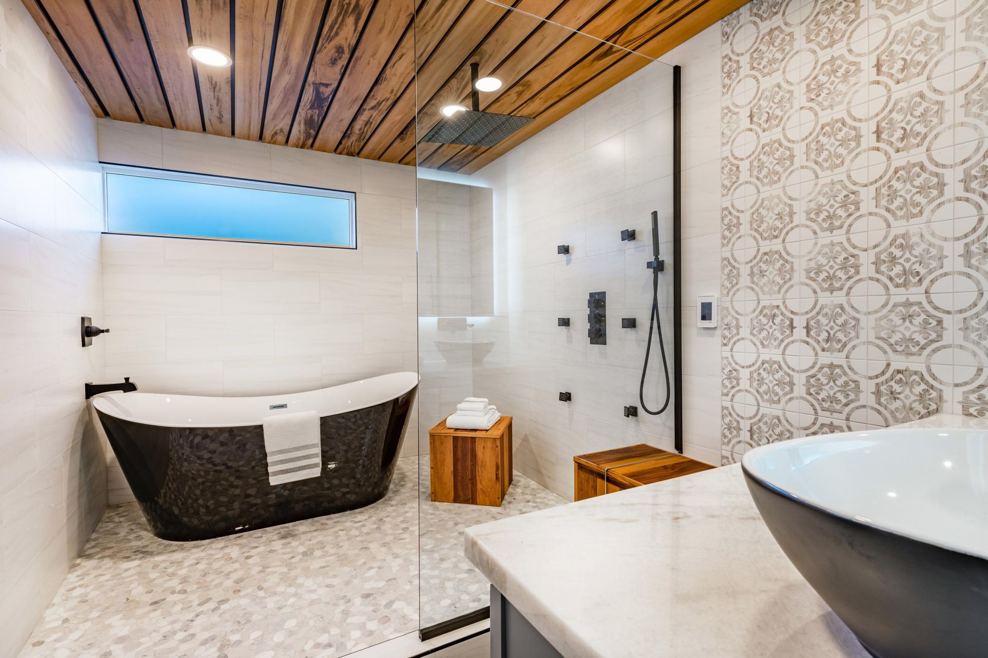 A bathroom with a tub, sink, and shower.