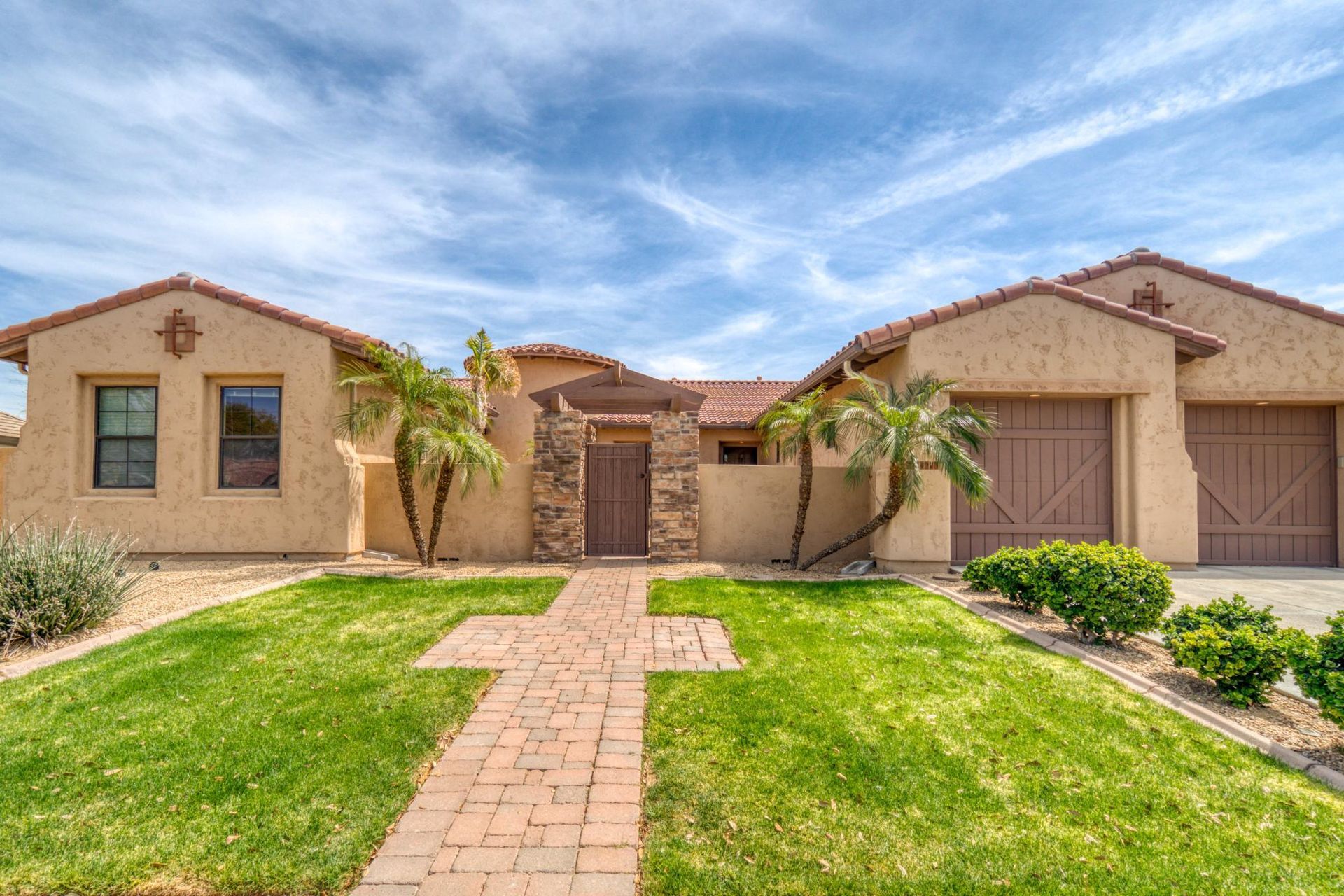 A large house with a brick walkway leading to it.