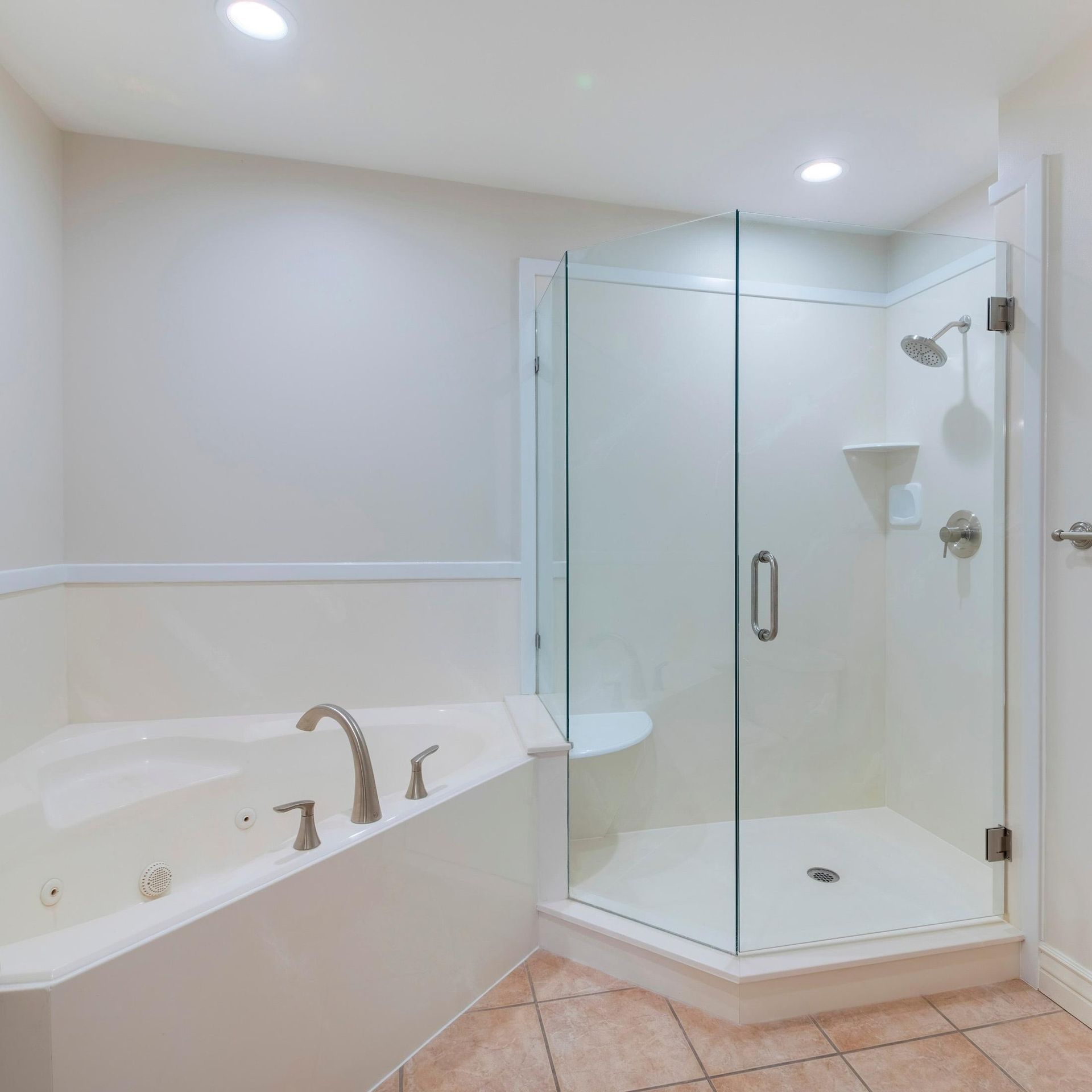 A bathroom with a tub and a walk in shower.