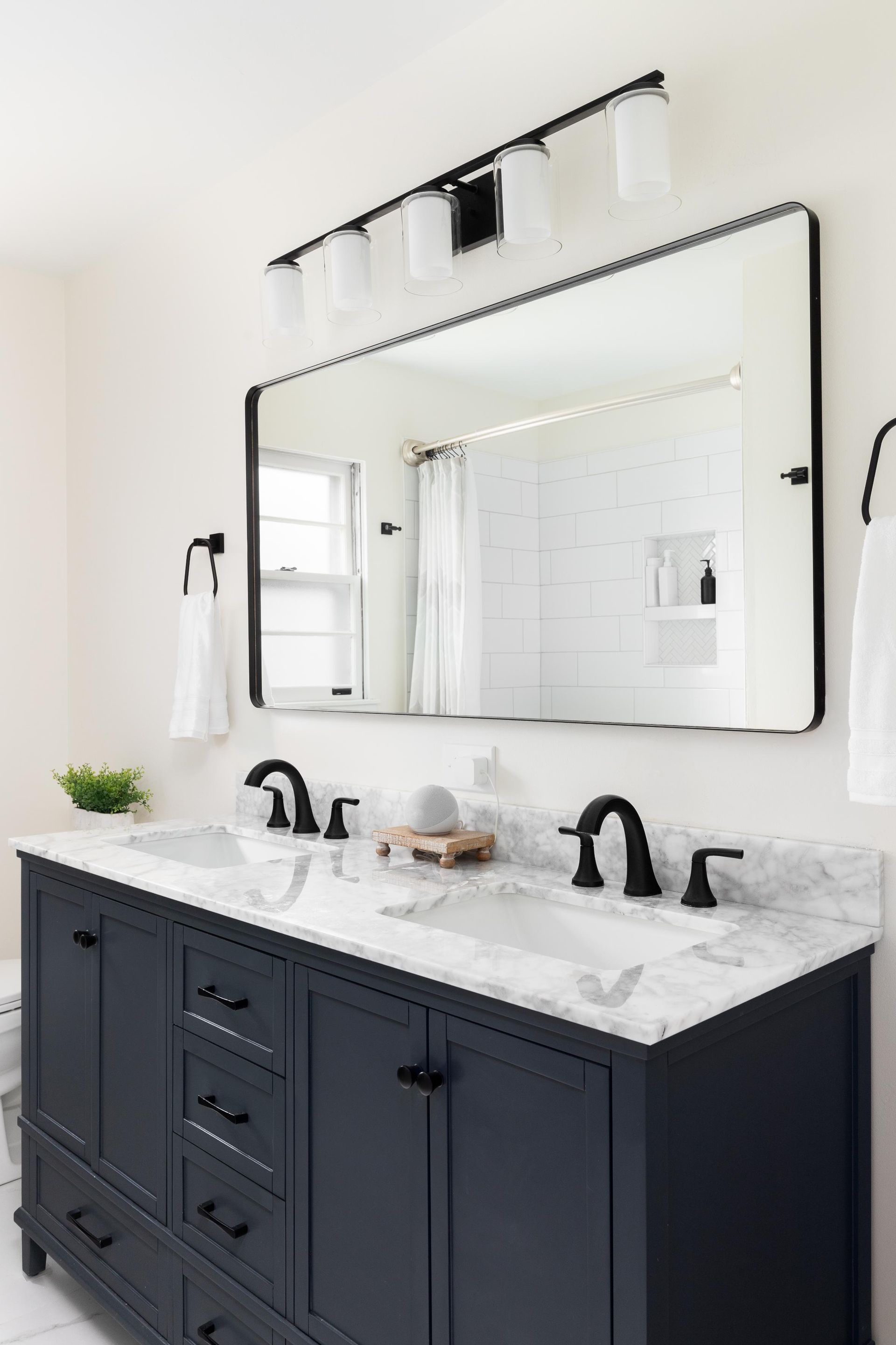 A bathroom with two sinks and a large mirror.