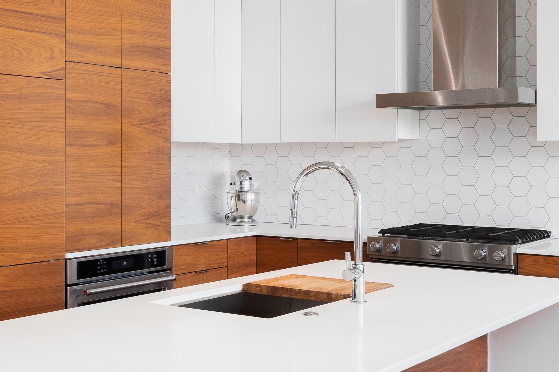 A kitchen with a sink, stove, and stainless steel appliances.