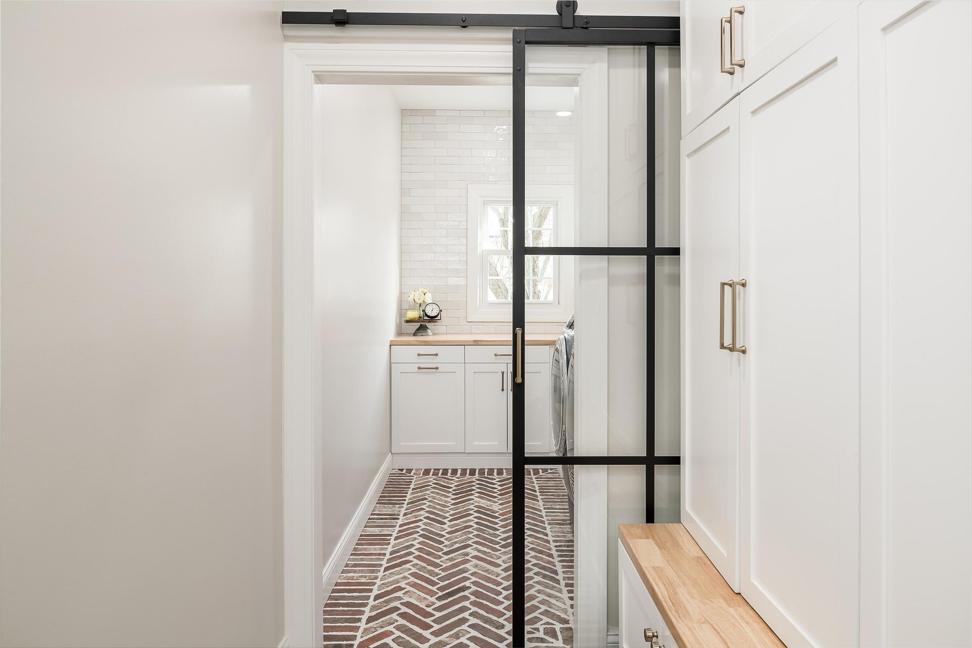 A hallway leading to a laundry room with a sliding glass door.