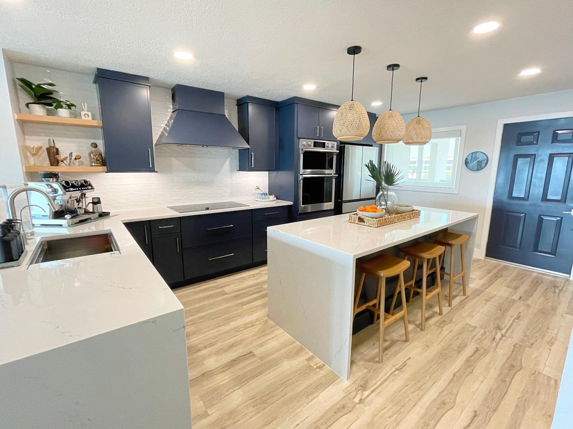 A kitchen with blue cabinets, white countertops, and a large island.