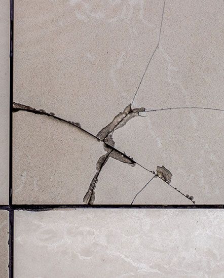 A close up of a cracked tile floor.