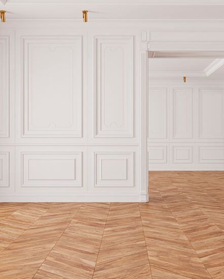 An empty room with white walls and a wooden floor.