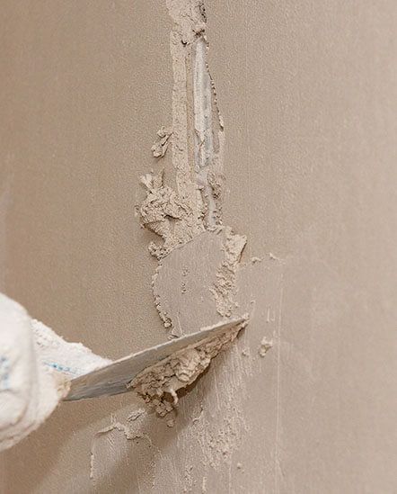 A person is plastering a wall with a spatula.