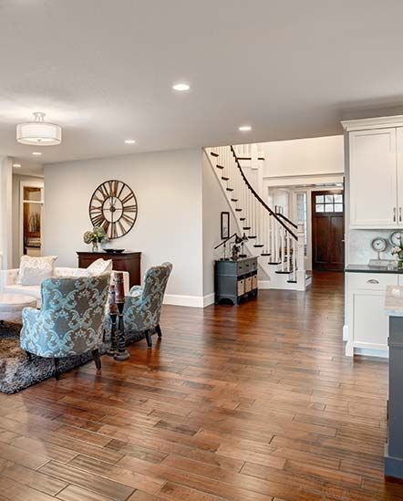 A living room with hardwood floors and a clock on the wall.