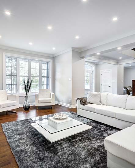 A living room with a white couch, chairs, and a coffee table.