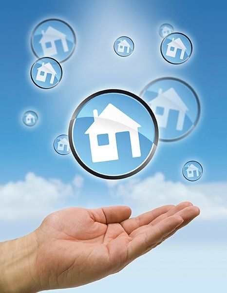A hand holds up a circular graphic of a house.