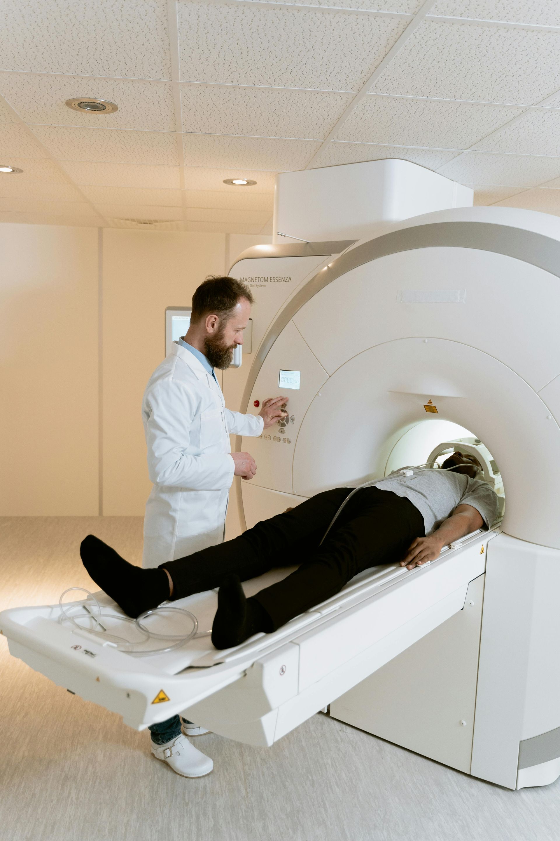 A man is laying on a bed in front of a mri machine.