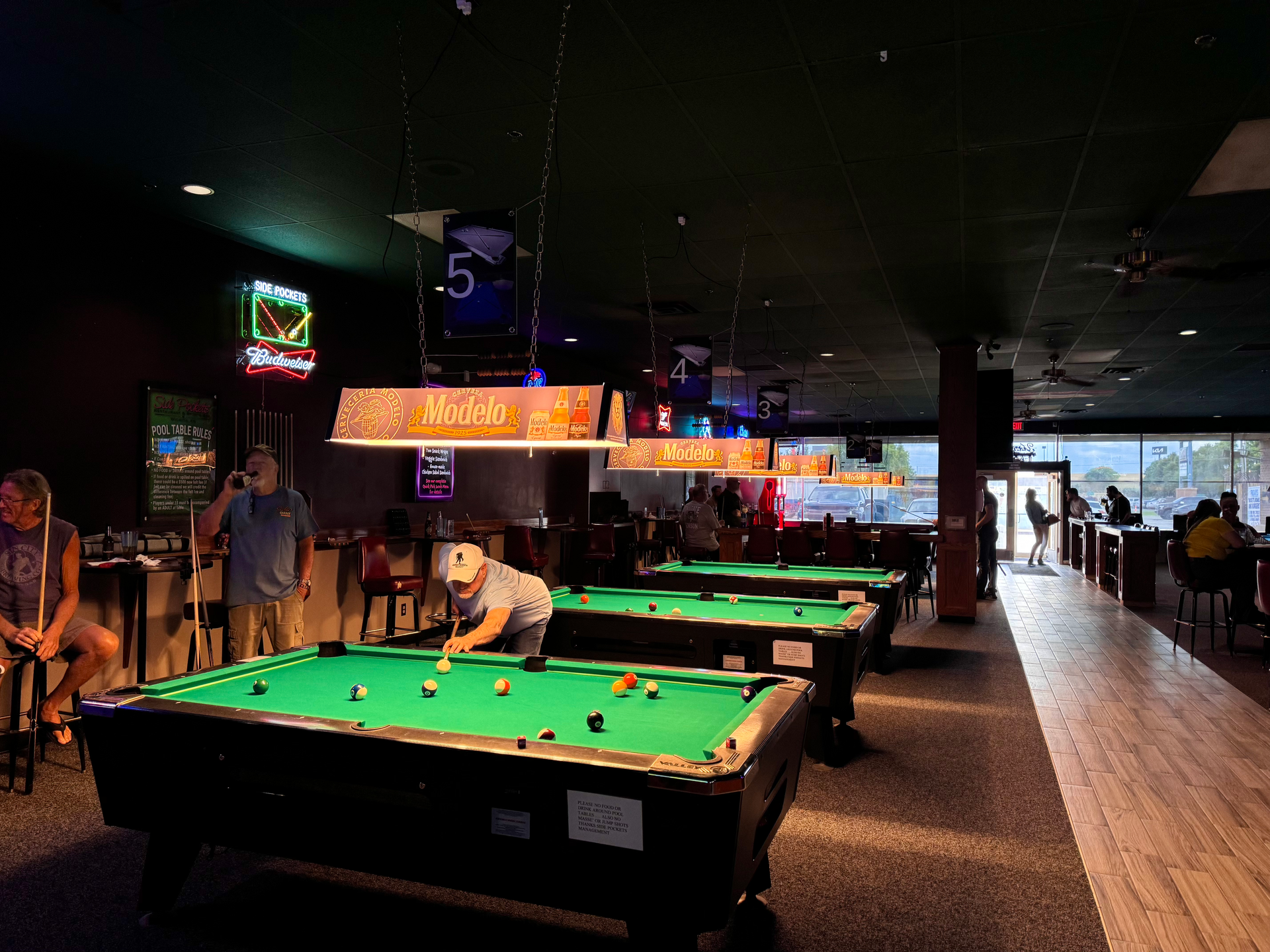 A man is playing pool at Side Pockets Wichita.