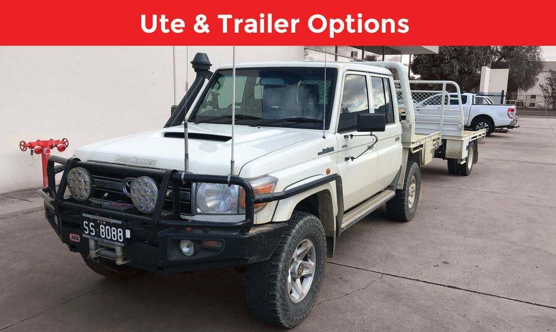 A white truck with a trailer attached to it is parked in a parking lot.