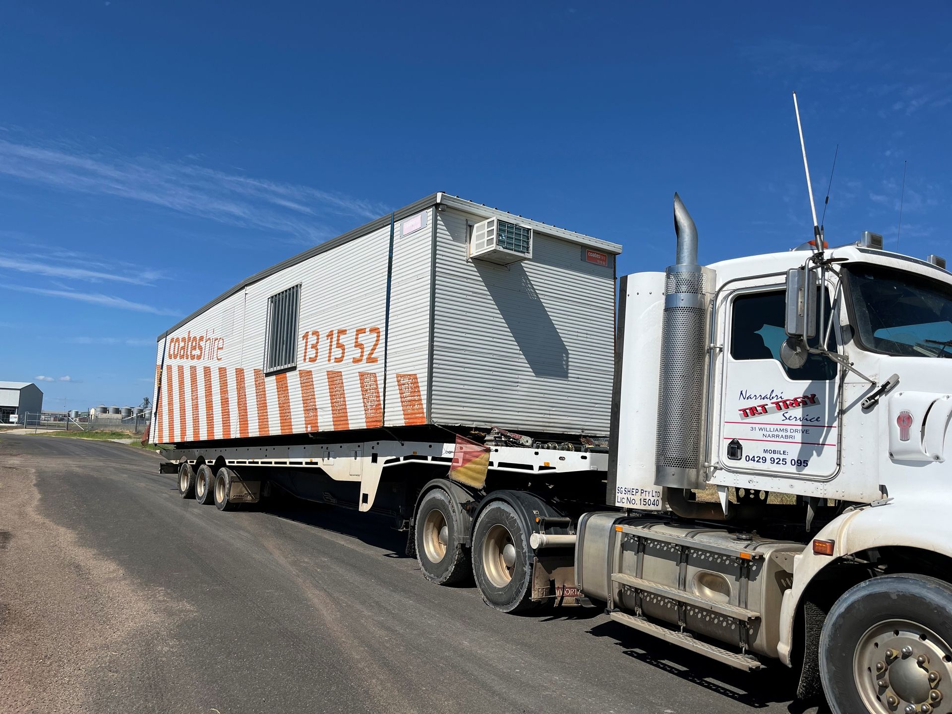 A forklift is sitting on the back of a semi truck.