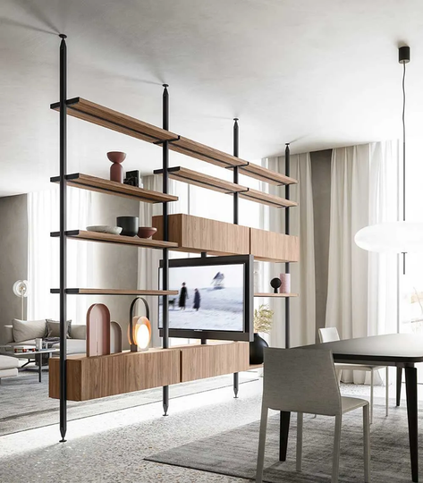 Scaffale in legno e nero che divide una stanza e contiene la TV e oggetti decorativi.