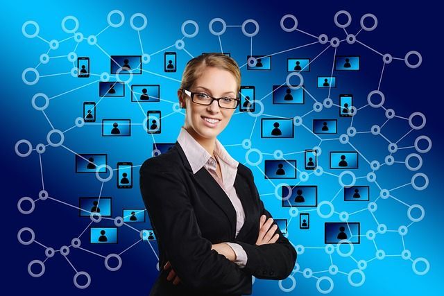 Businesswoman with crossed arms, smiling, in front of a blue digital network.
