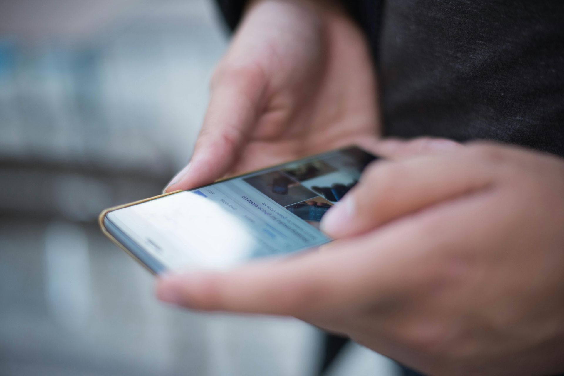A person is holding a cell phone in their hands.