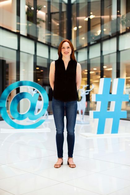 A person is holding a cell phone with social media icons on the screen.