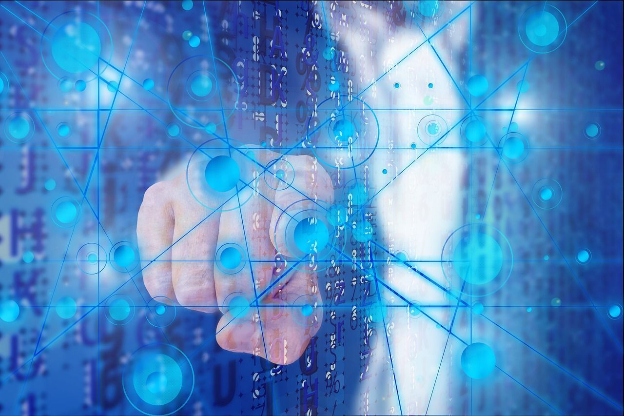 Person's finger pointing toward blue digital network with glowing nodes and lines.