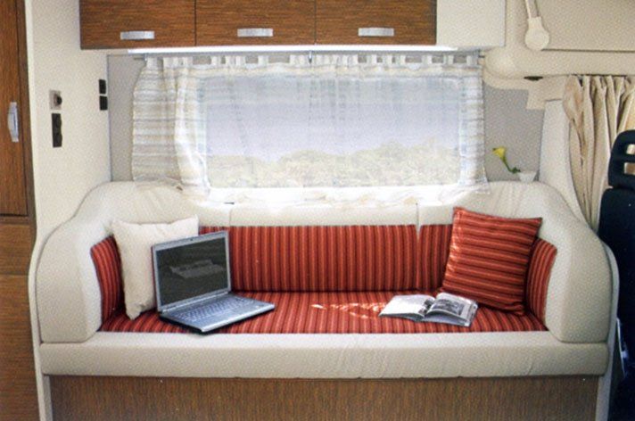 divanetto di un camper con rivestimento rosso a righe