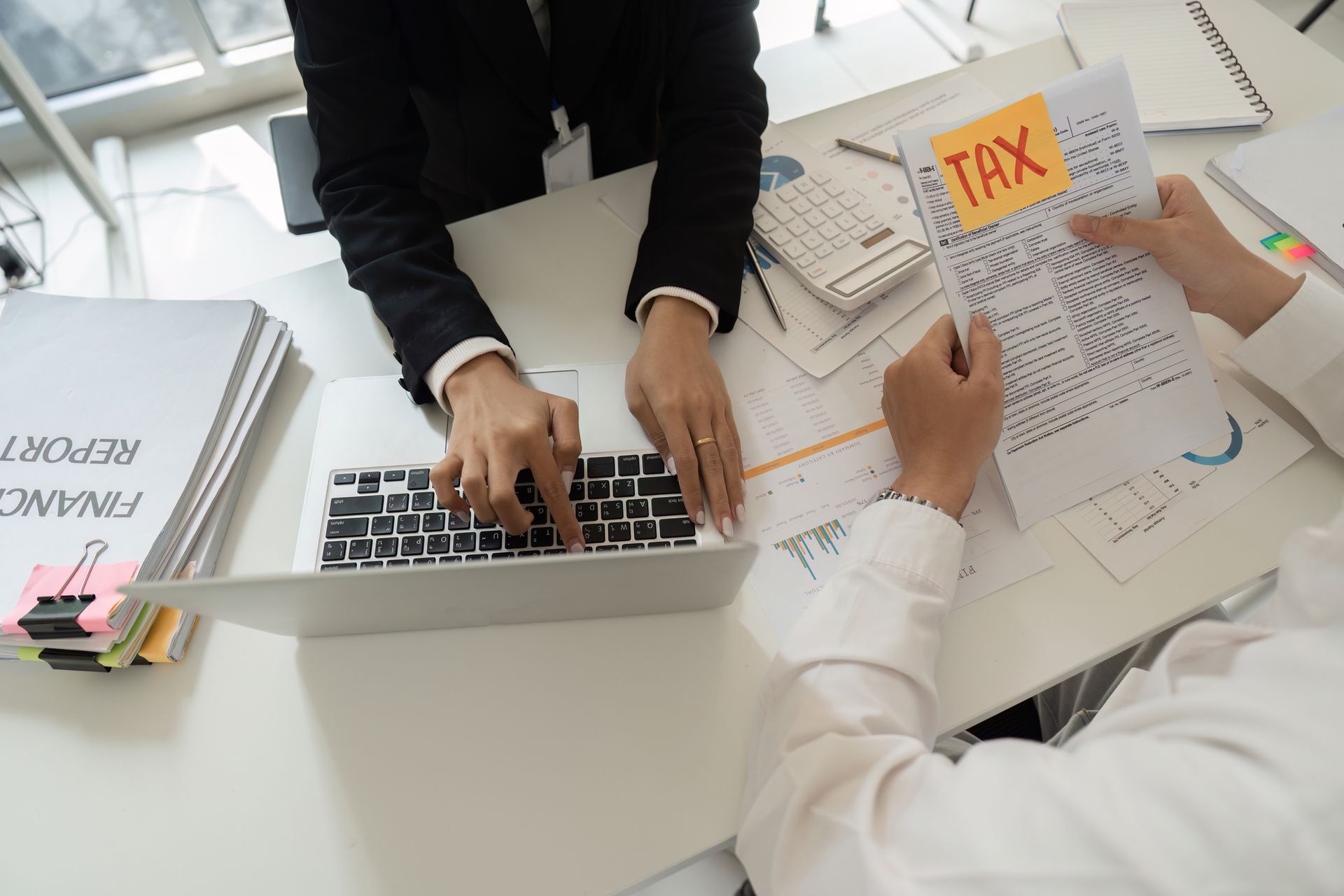 A tax consultant assisting a client with financial reports and tax documents. A tax consultant assisting a client with financial reports and tax documents.