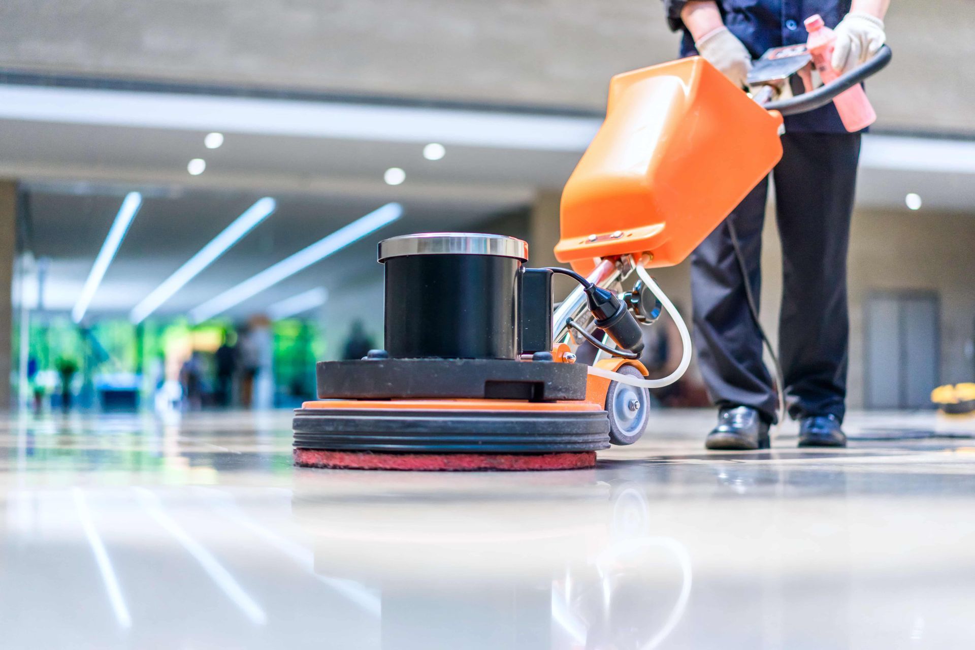 A person is cleaning a floor with a machine.