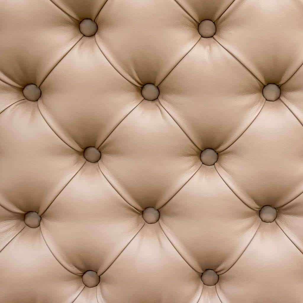 A close up of a quilted leather wall with buttons.