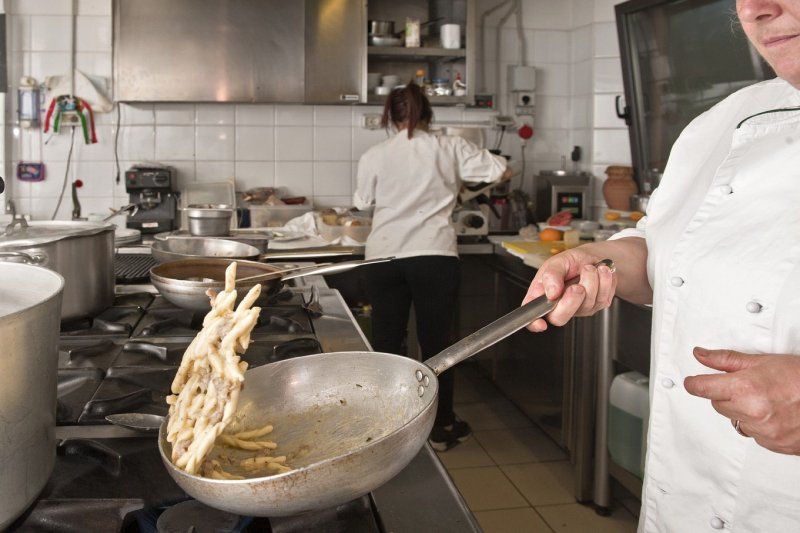 Un cuoco che prepara un piatto di trofie