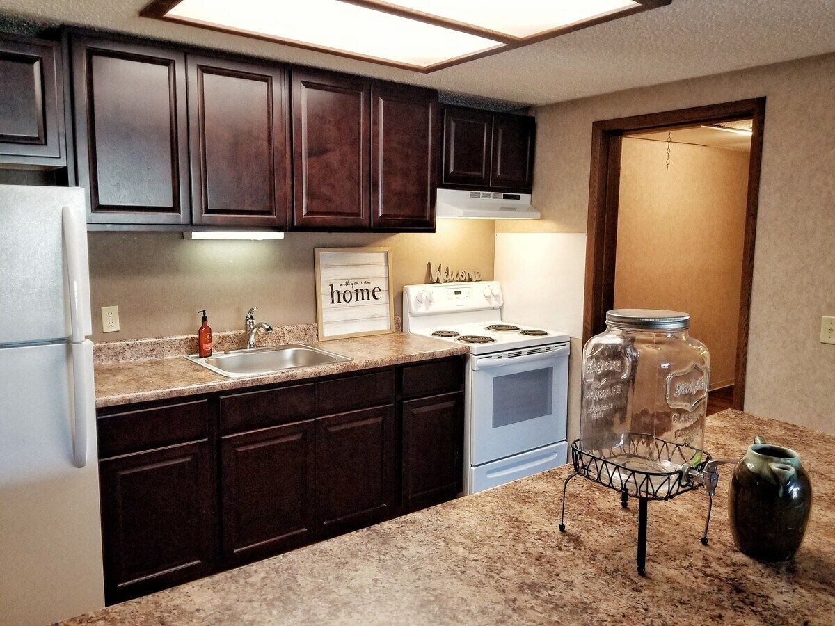 A kitchen with a sign that says home on the wall