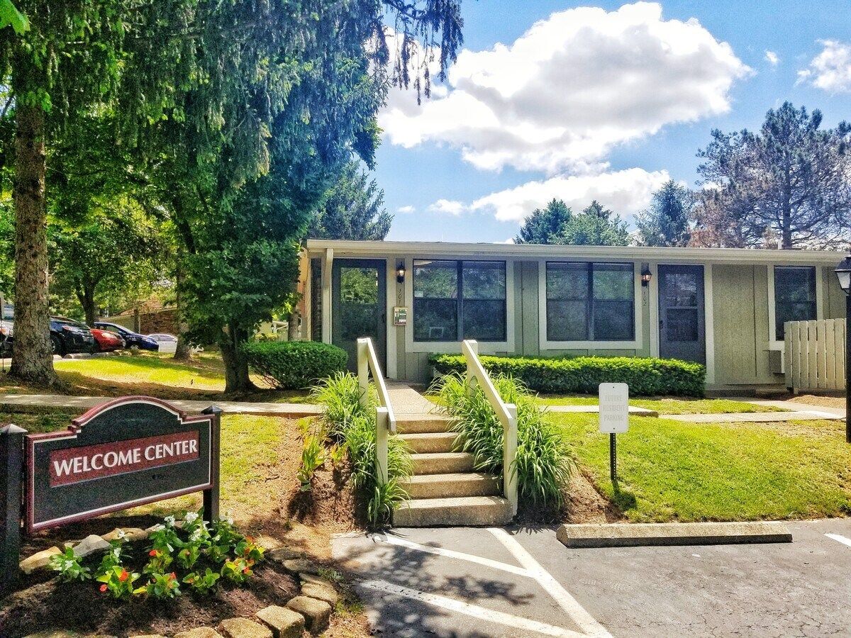 A house with stairs leading up to it and a welcome sign in front of it.