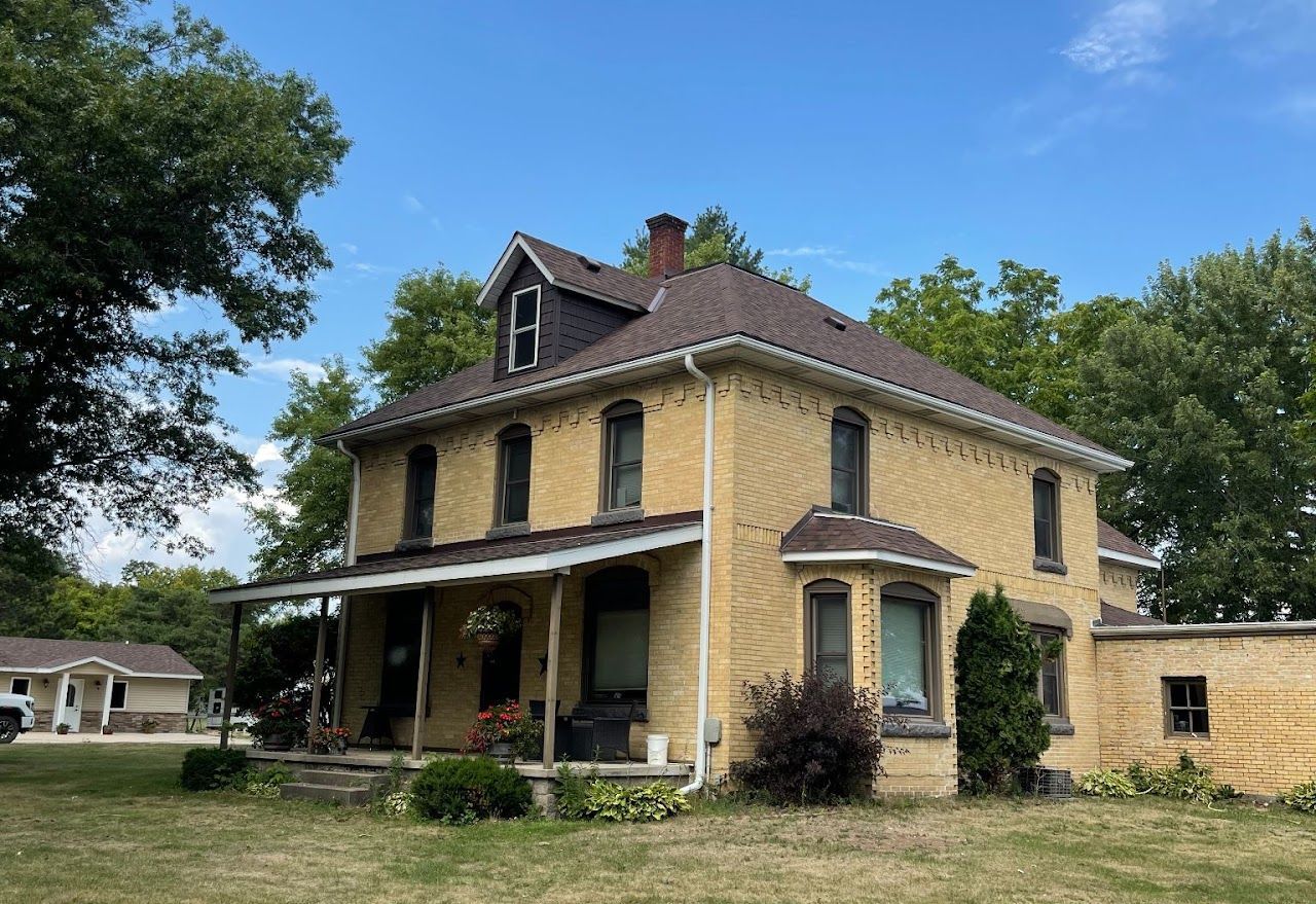 A large brick house with a porch and a roof