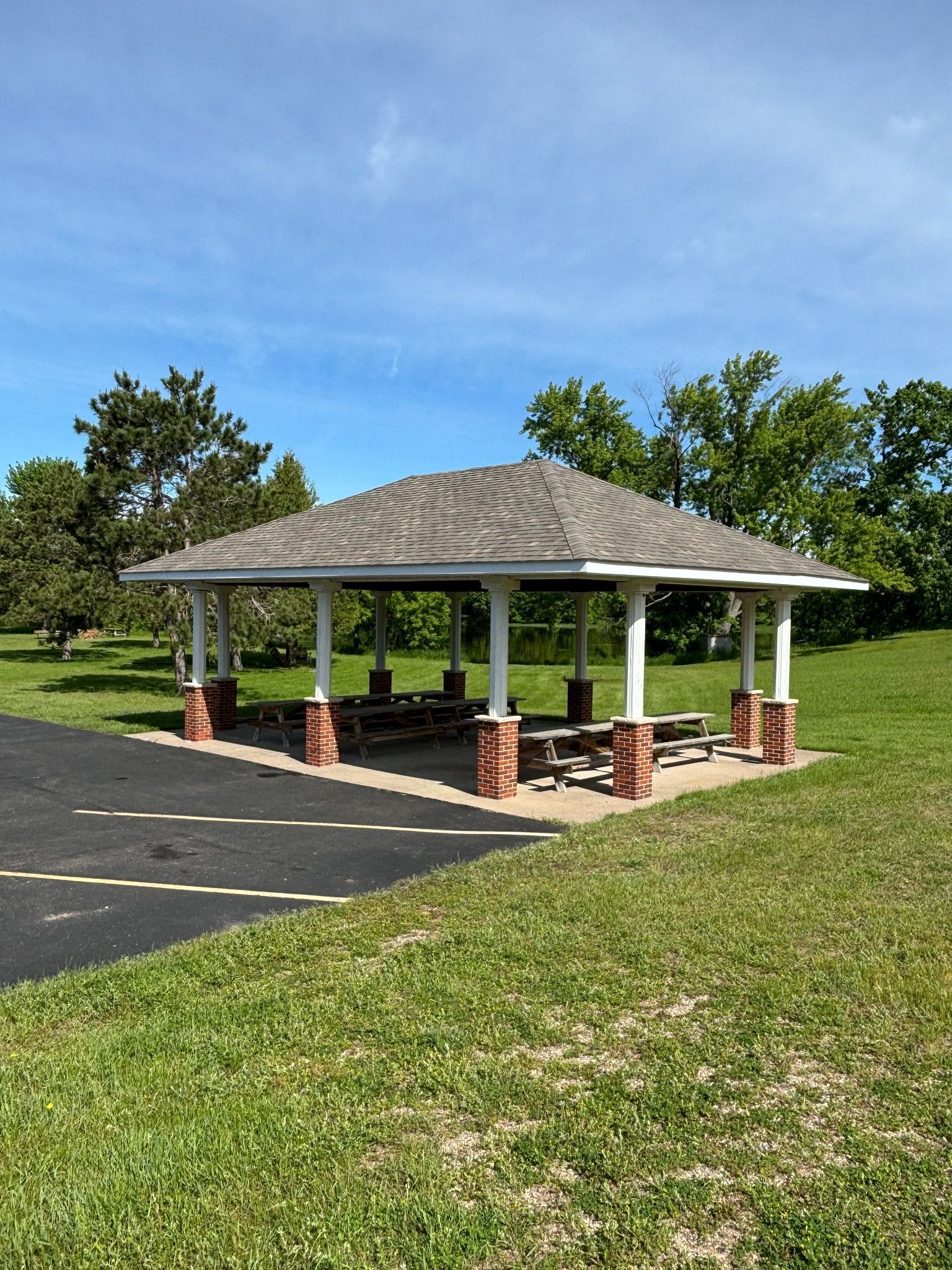 A picnic shelter with tables and benches in a park.