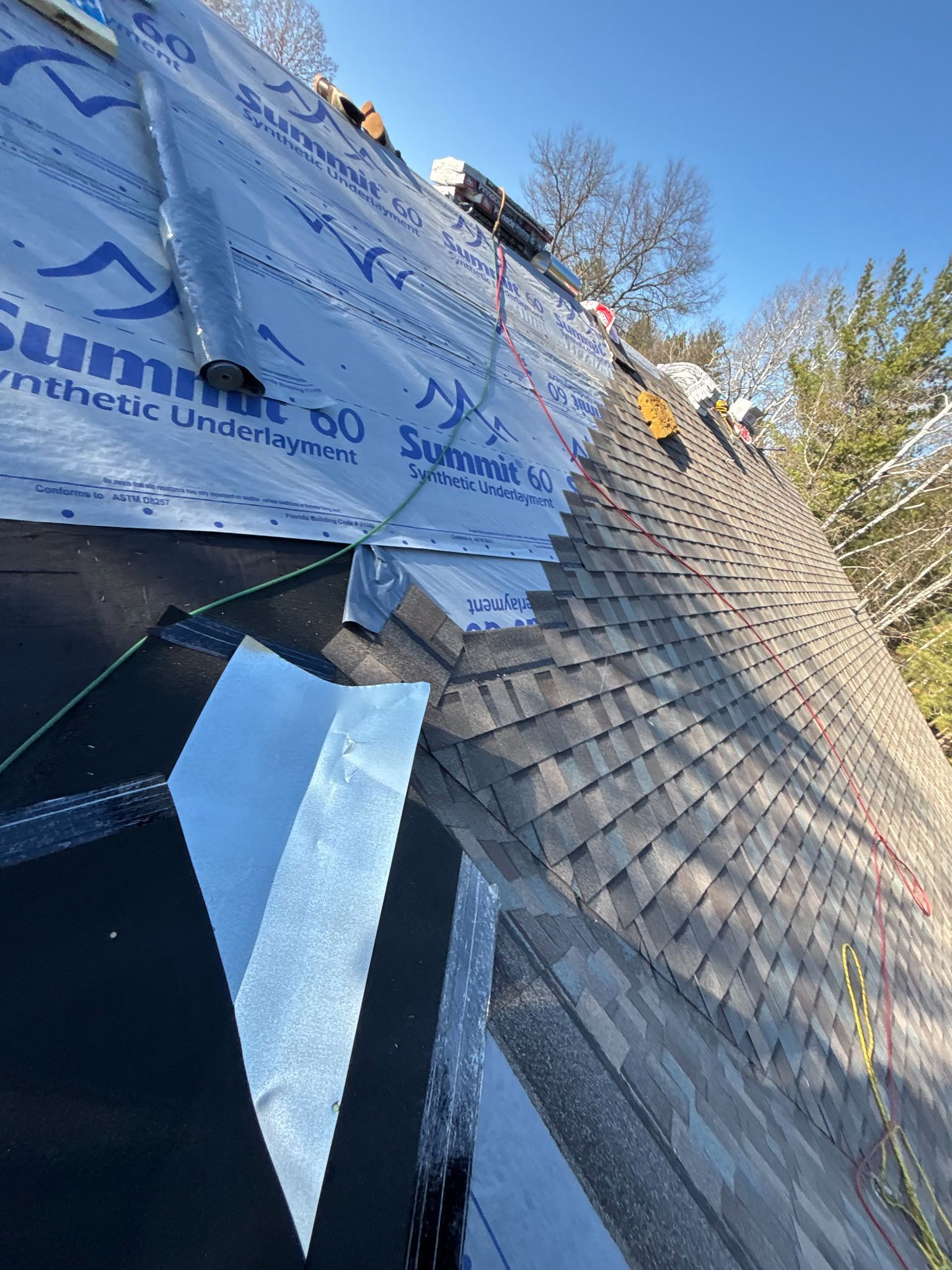 A roof with a lot of shingles being installed on it.