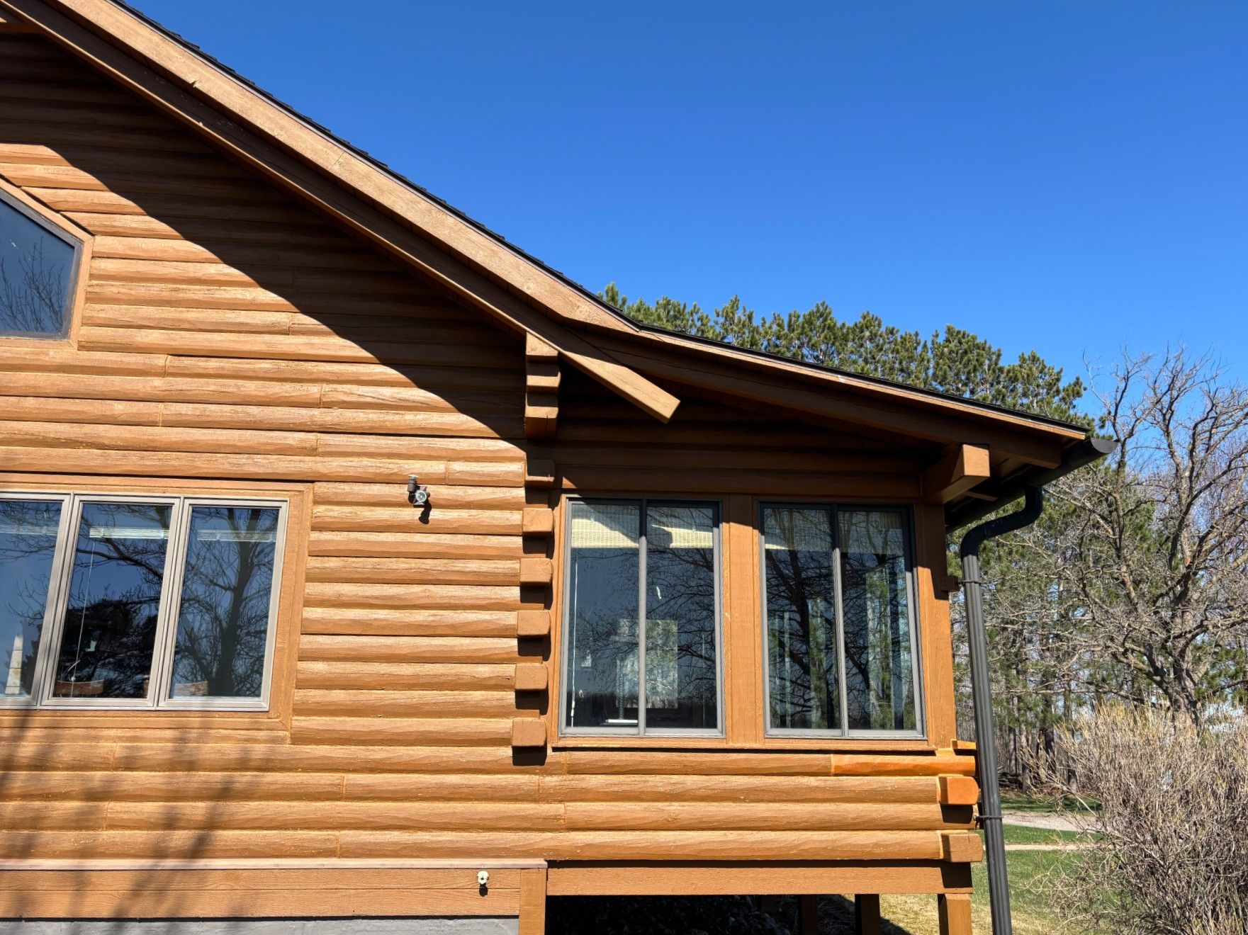 A small house with a metal roof and a picnic table in front of it.