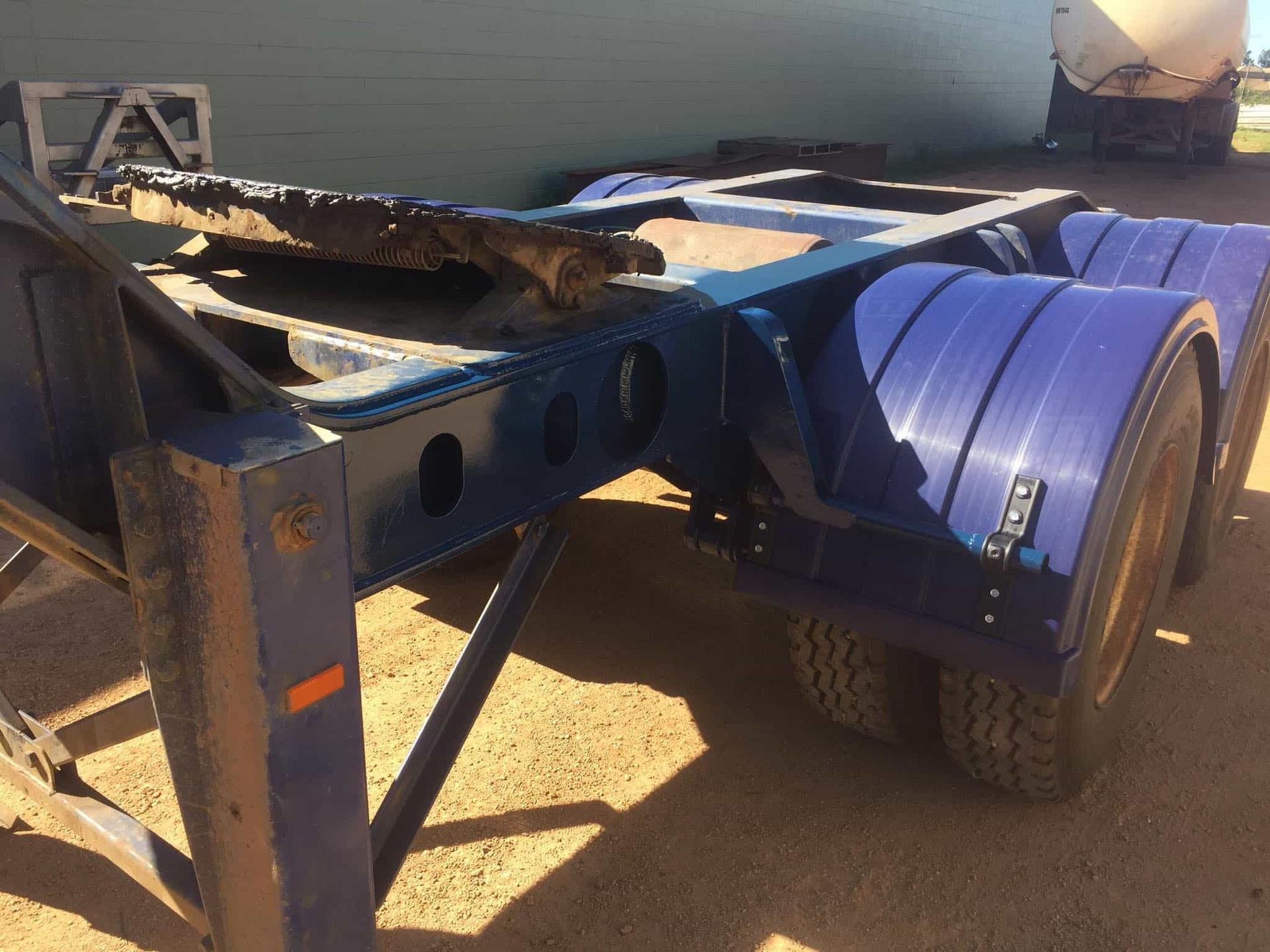 Blue Semi-trailer Chassis With Tires on a Dirt Surface — Boycey's Custom Engineering in Atherton, QLD